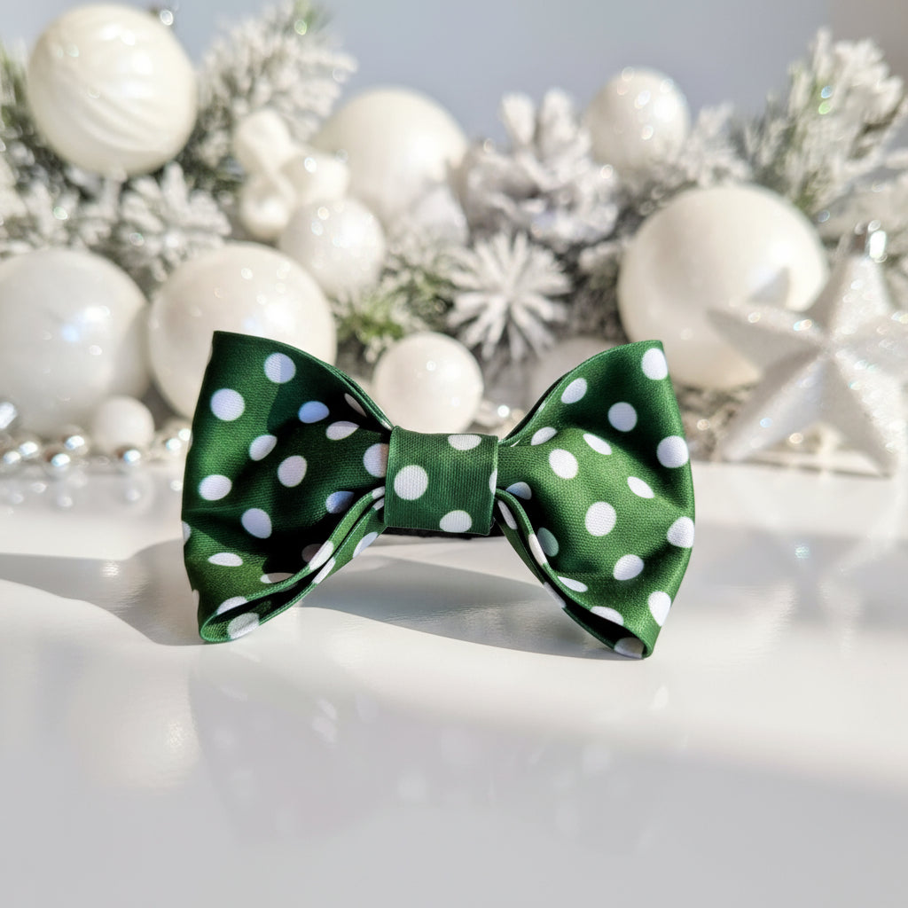 Green bow with white polka dots on a light gray background
