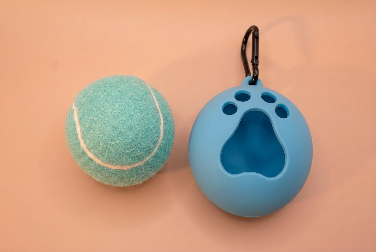A blue silicone pet bal case with a paw print cutout and black carabiner clip.