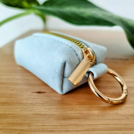 a small blue dog poop bag pouch with a gold zipper